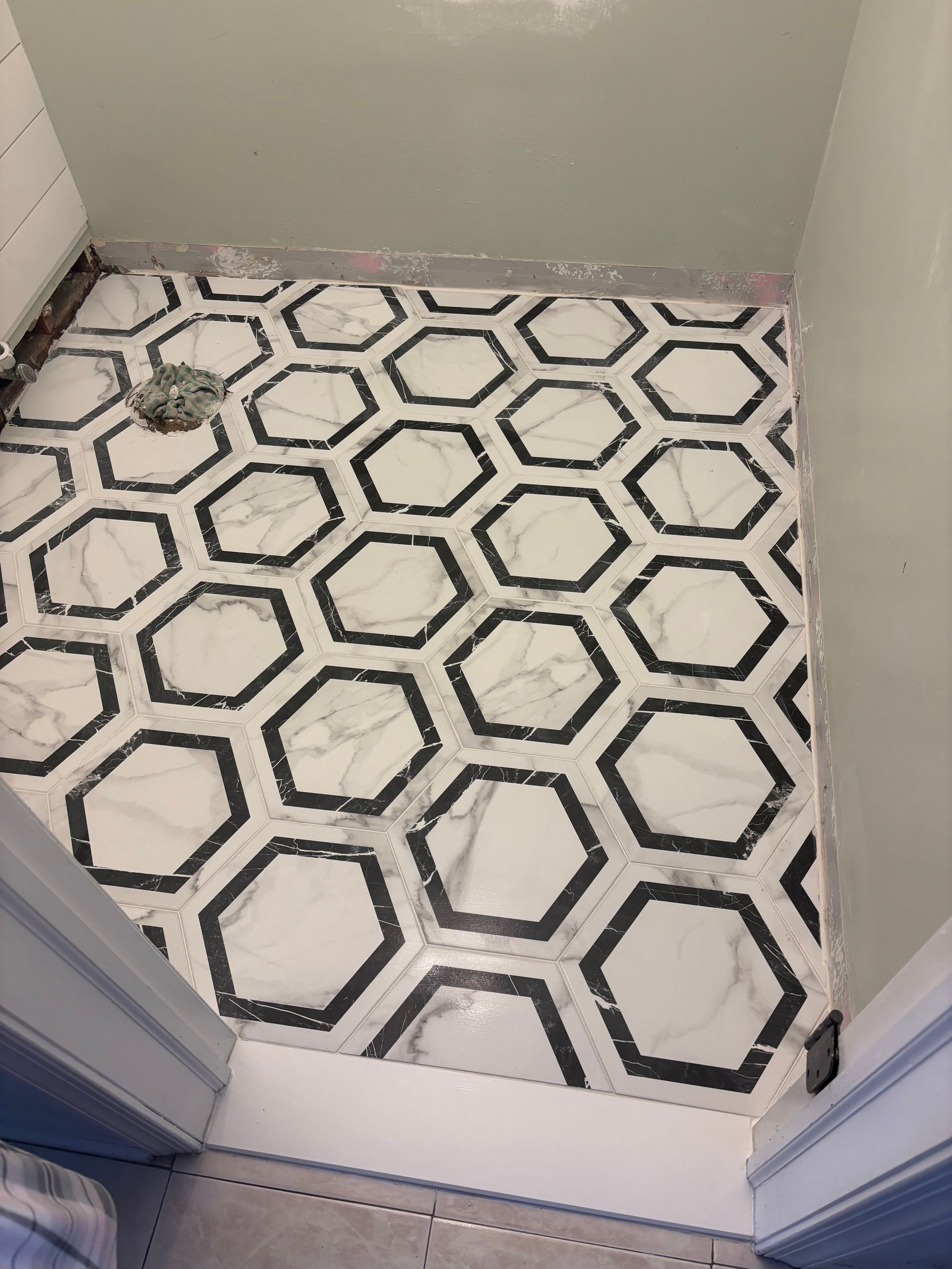A tiled bathroom floor with a black and white hexagon pattern in MArlboro, NJ.