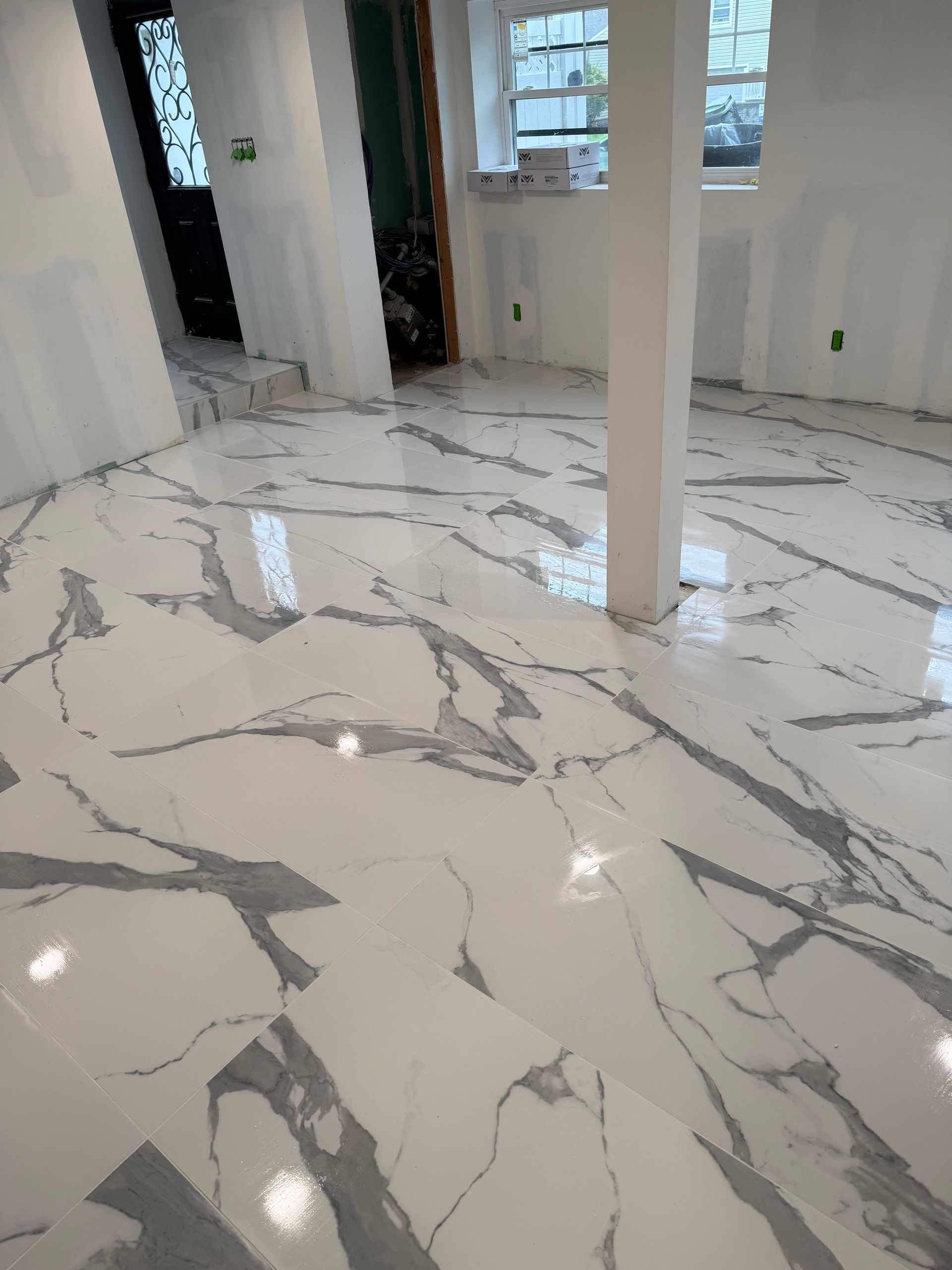 A white marble tile floor in a room with columns in Marlboro, NJ.