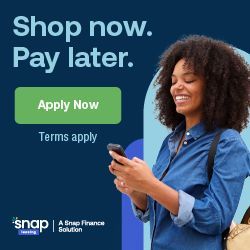 A person smiling while looking at a smartphone, next to