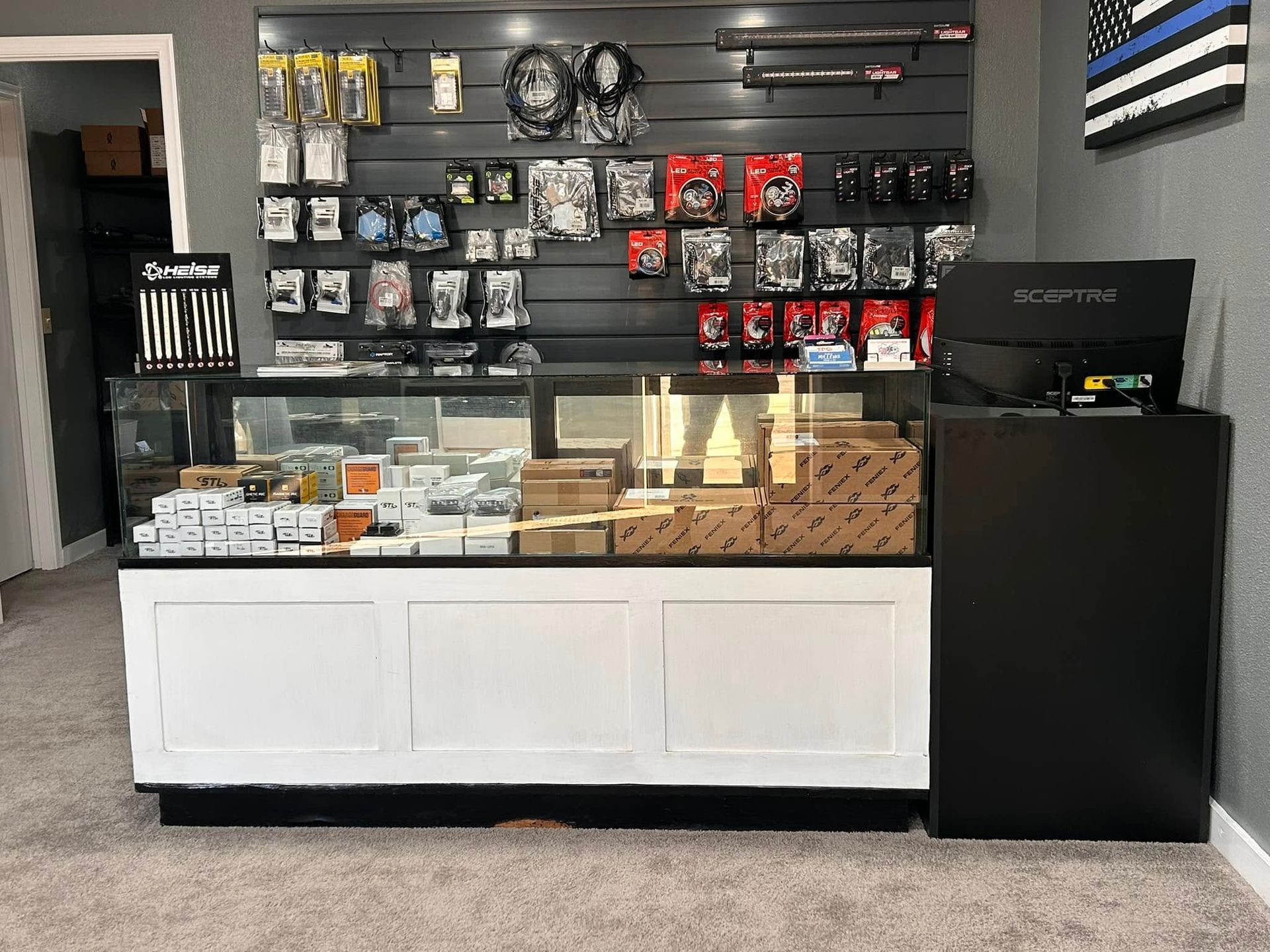 Storefront interior with display cases, black shelving, and various products.