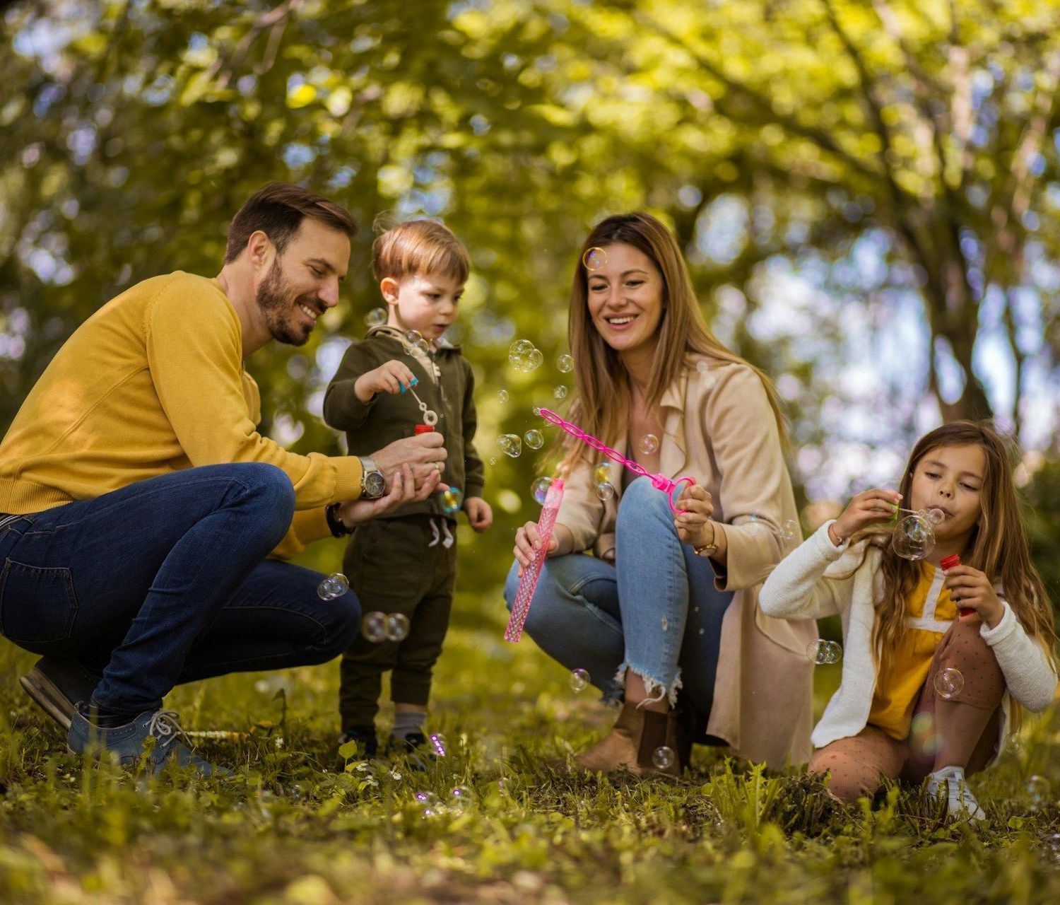 A family is blowing soap bubbles in a park.