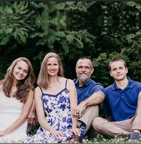 A group of people are posing for a picture while sitting in the grass