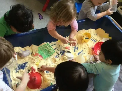 A group of children are playing in a sandbox.