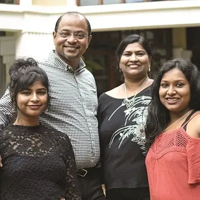 A man and three women are posing for a picture together