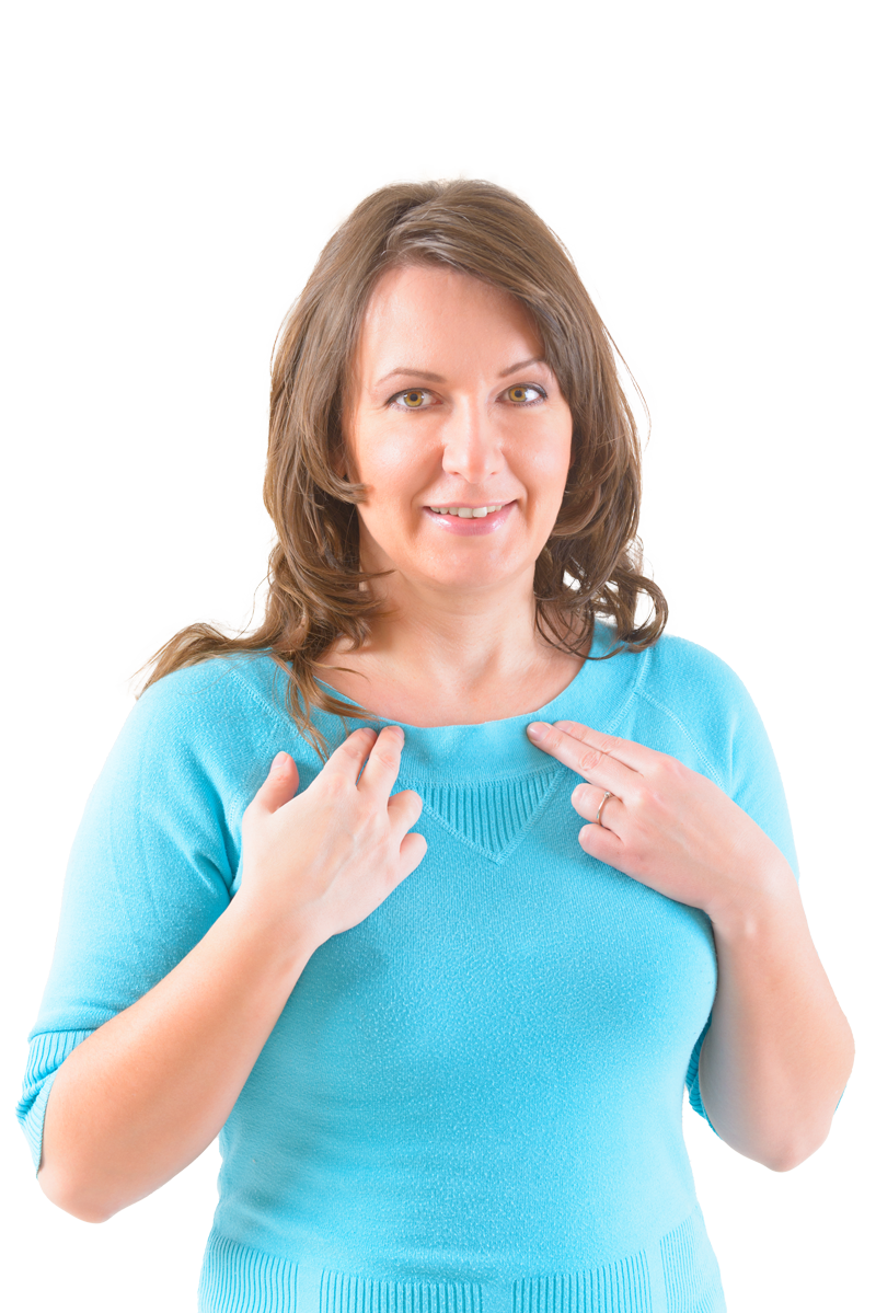 Woman in a blue sweater points to her chest, smiling, against a white background.