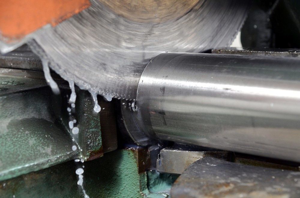 A Circular Saw Is Cutting A Piece Of Metal — Northern Glazing Glass & Aluminium In Smithfield, QLD