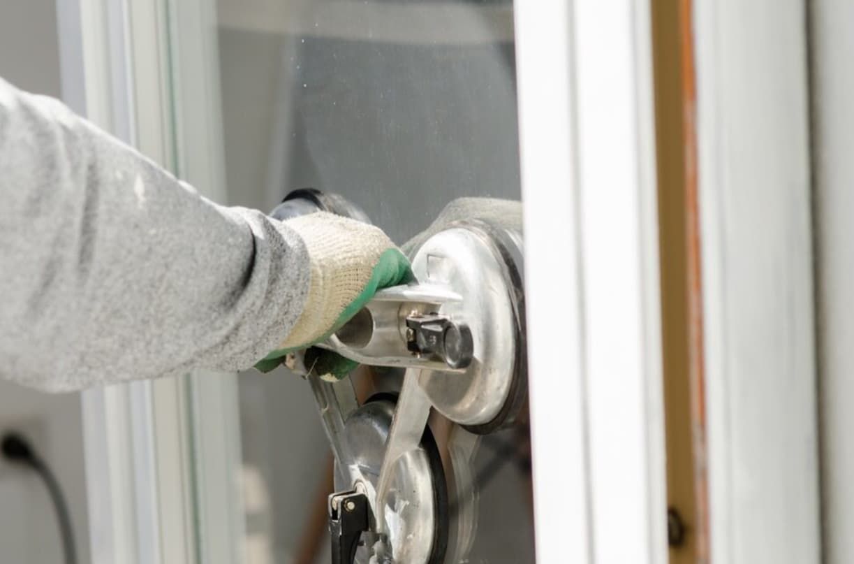 A Person Is Installing A Window With A Suction Cup — Northern Glazing Glass & Aluminium In Smithfield, QLD