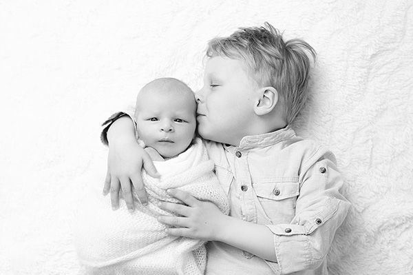 Geschwisterkuss beim Babyfotograf München – authentische Familienmomente