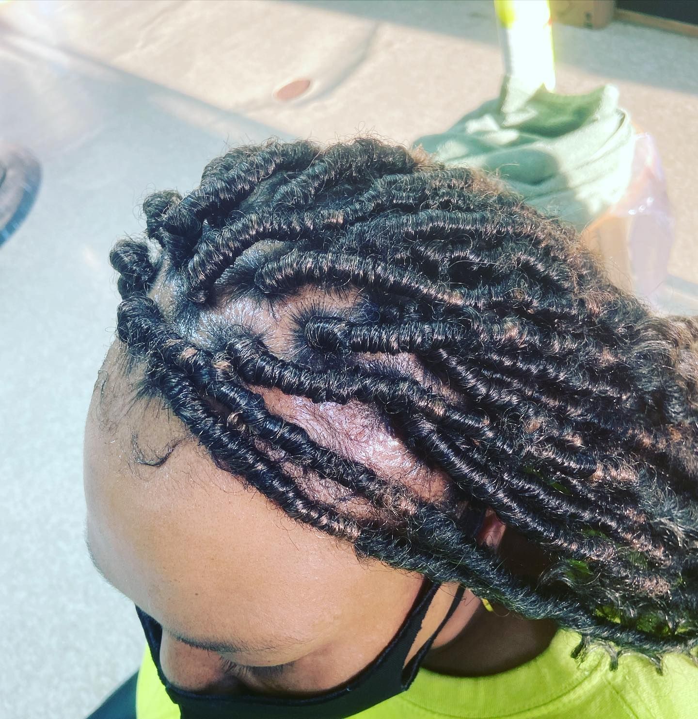 Person with black locs hairstyle; wearing a black face mask.