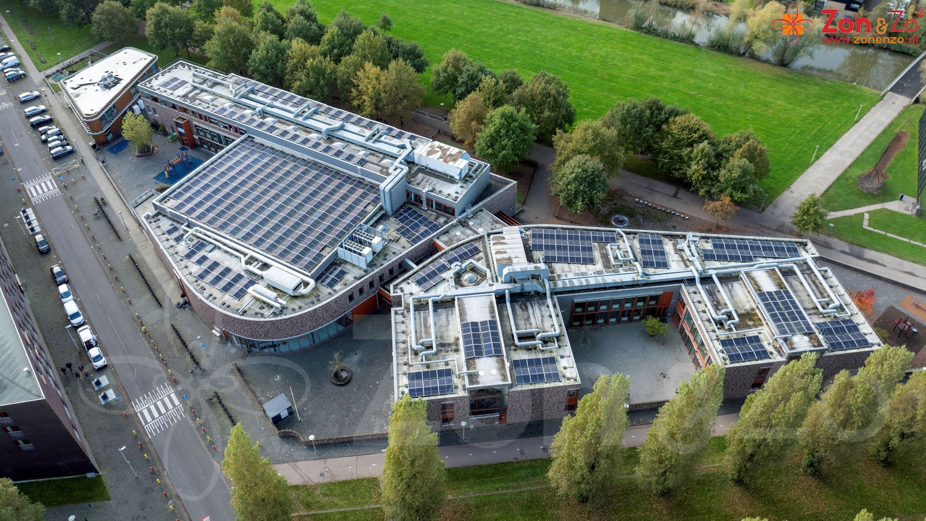 Een luchtfoto van een groot gebouw met zonnepanelen op het dak.