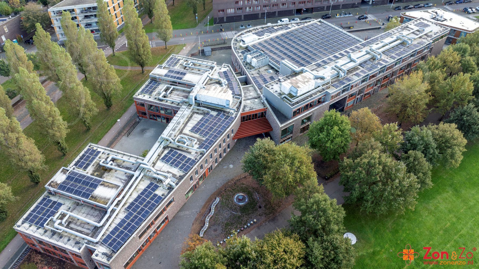 Een luchtfoto van een groot gebouw met zonnepanelen op het dak