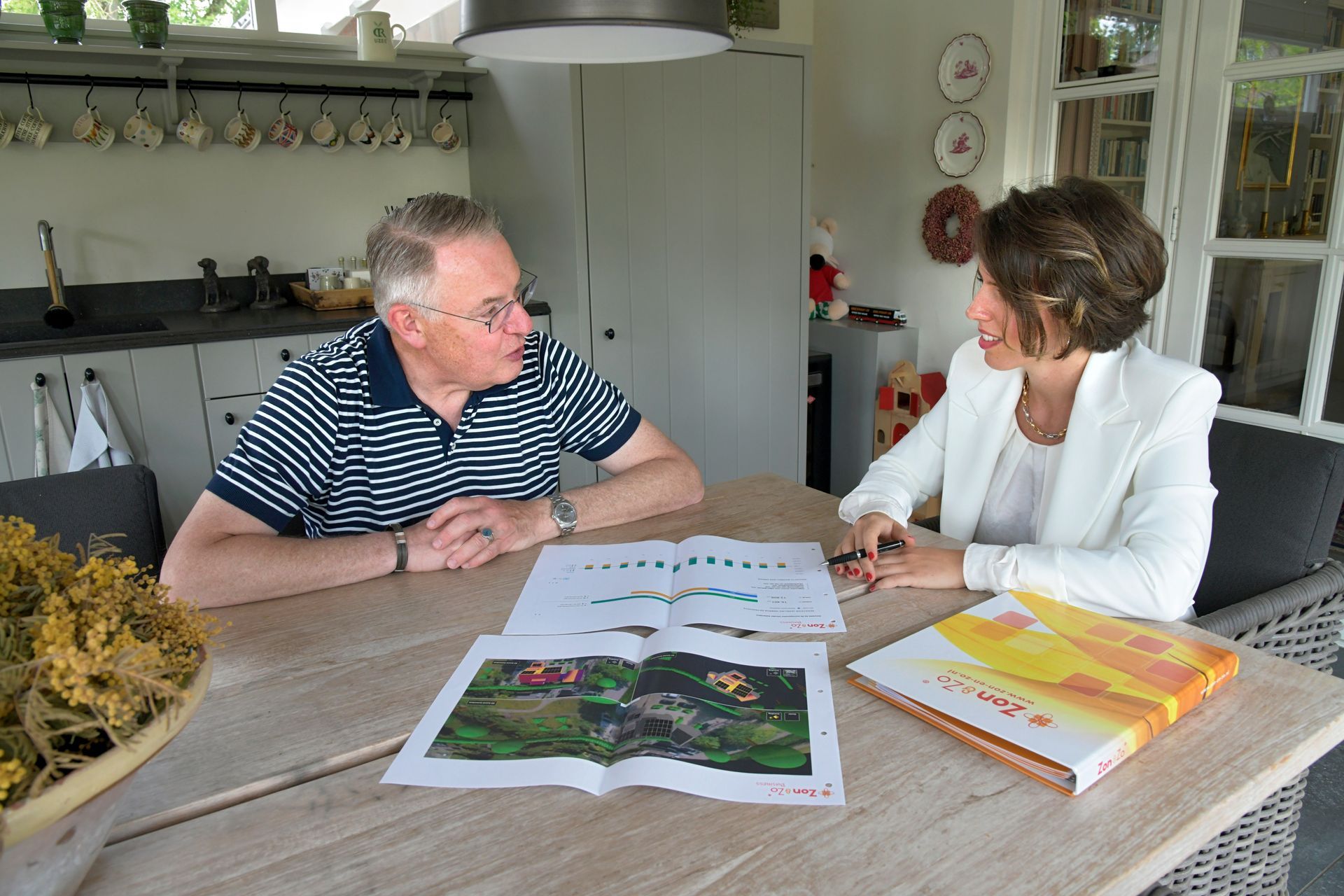 Een man en een vrouw zitten aan een tafel en bekijken een kaart.