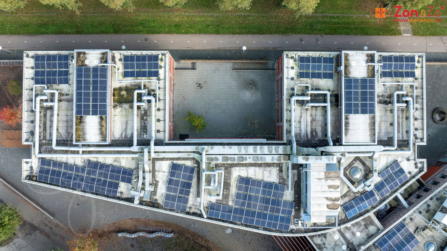 Een luchtfoto van een gebouw met zonnepanelen op het dak.