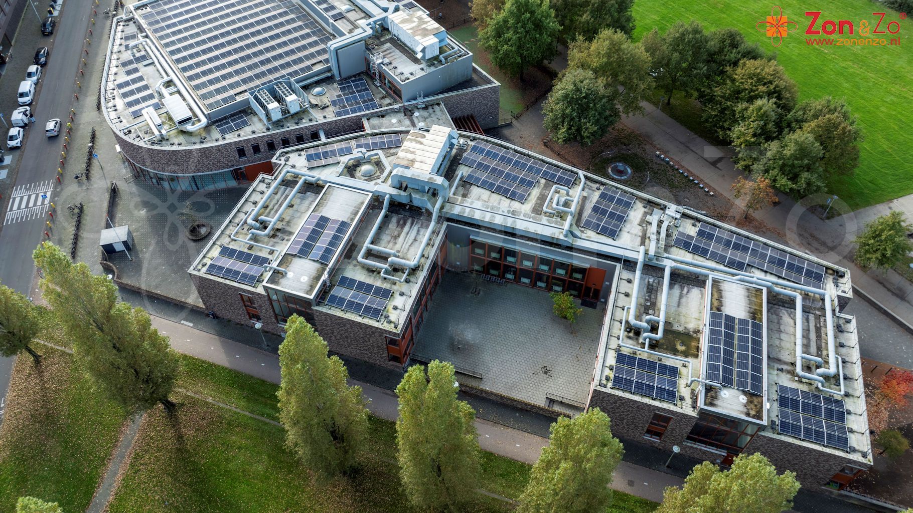 Een luchtfoto van een groot gebouw met zonnepanelen op het dak.