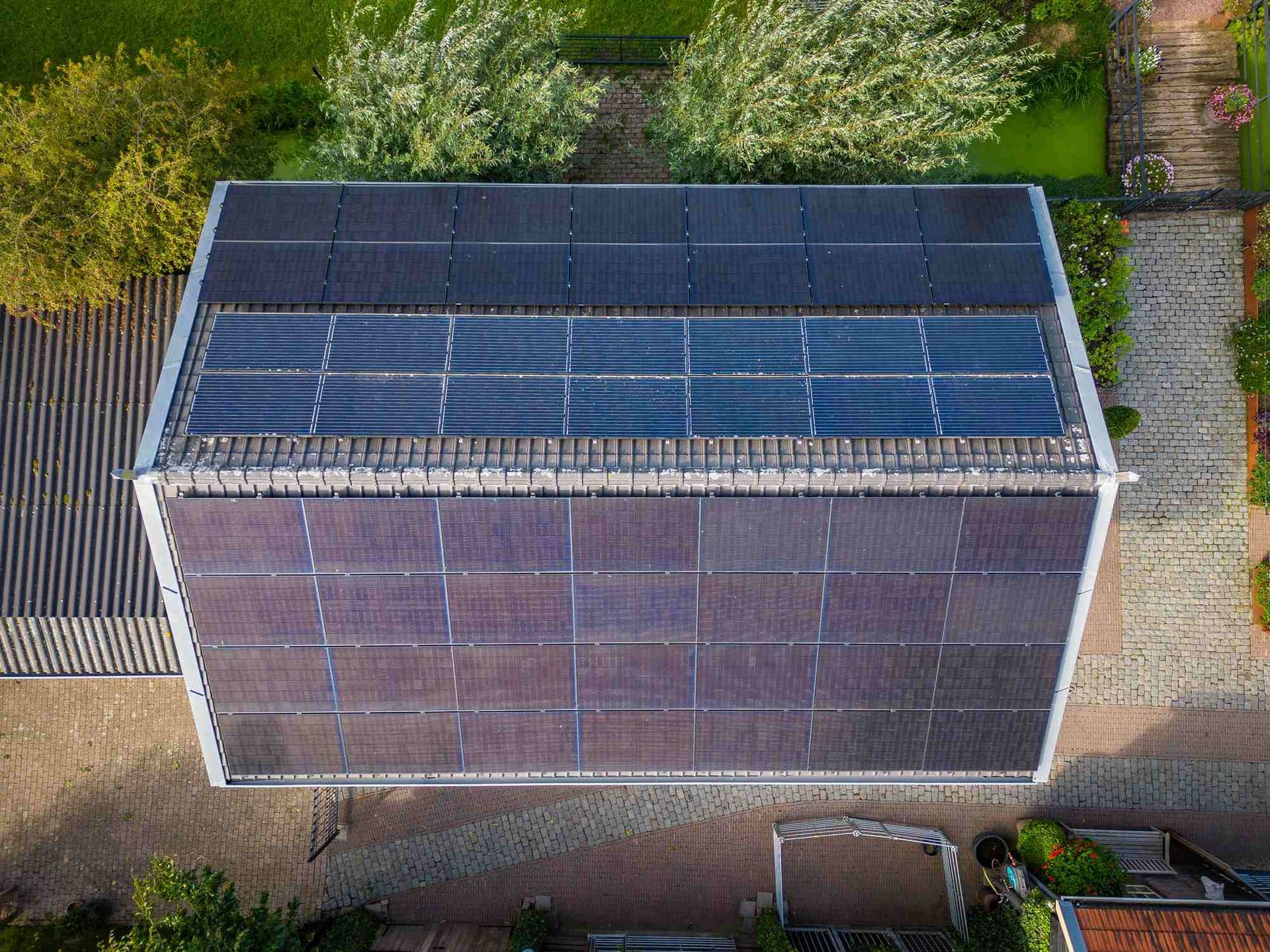 Een luchtfoto van een huis met zonnepanelen op het dak.