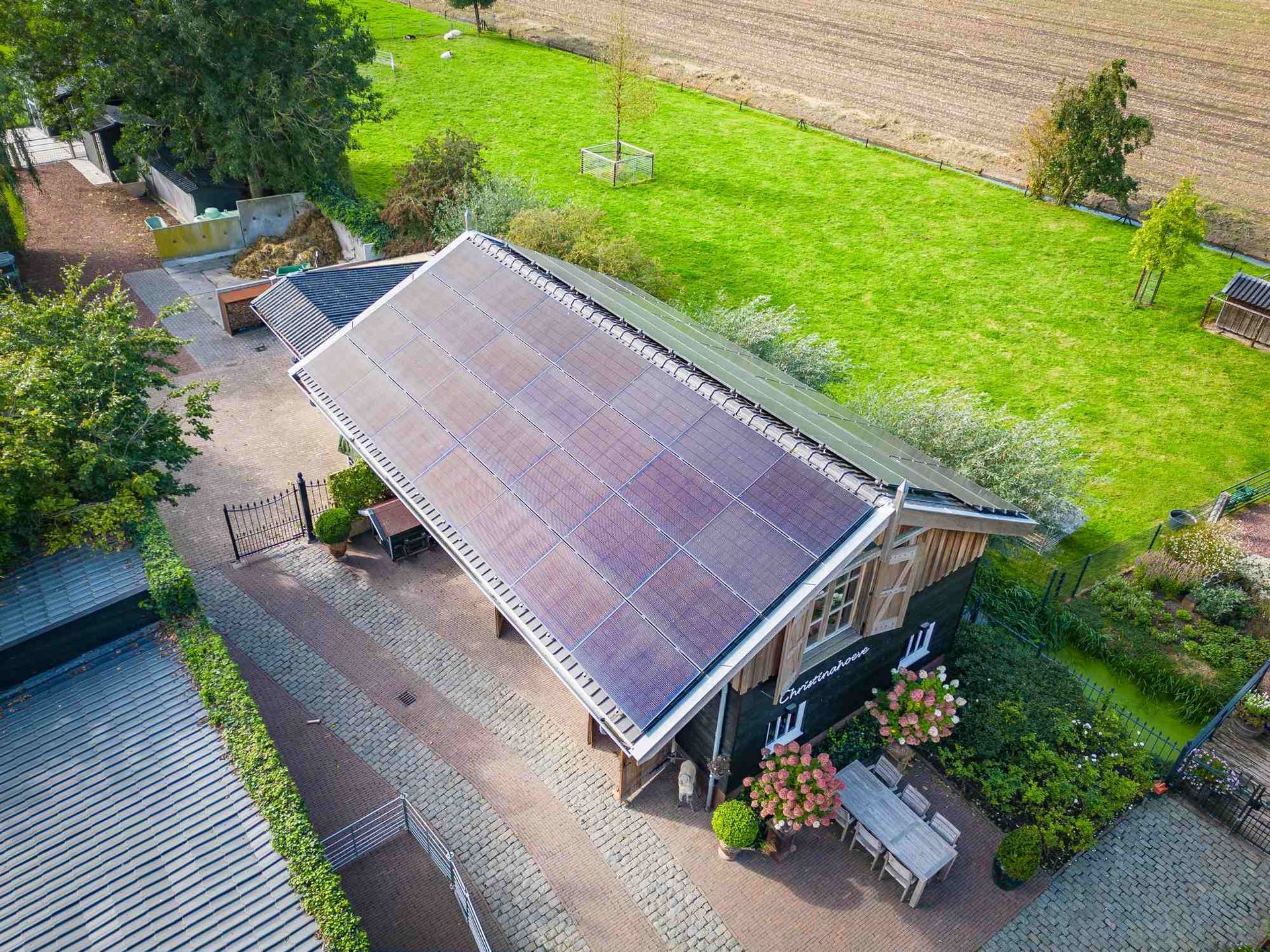 Een luchtfoto van een huis met zonnepanelen op het dak.