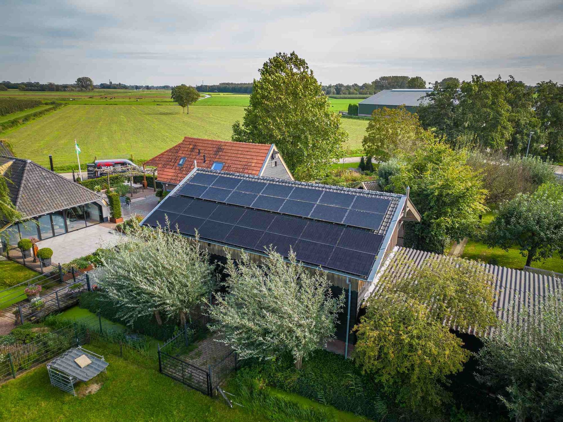 Een luchtfoto van een huis met zonnepanelen op het dak.
