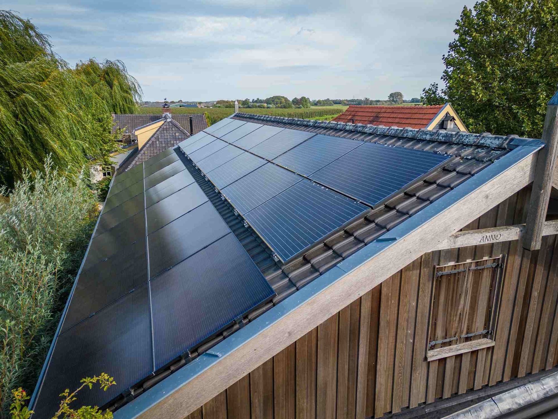 Een houten gebouw met zonnepanelen op het dak.