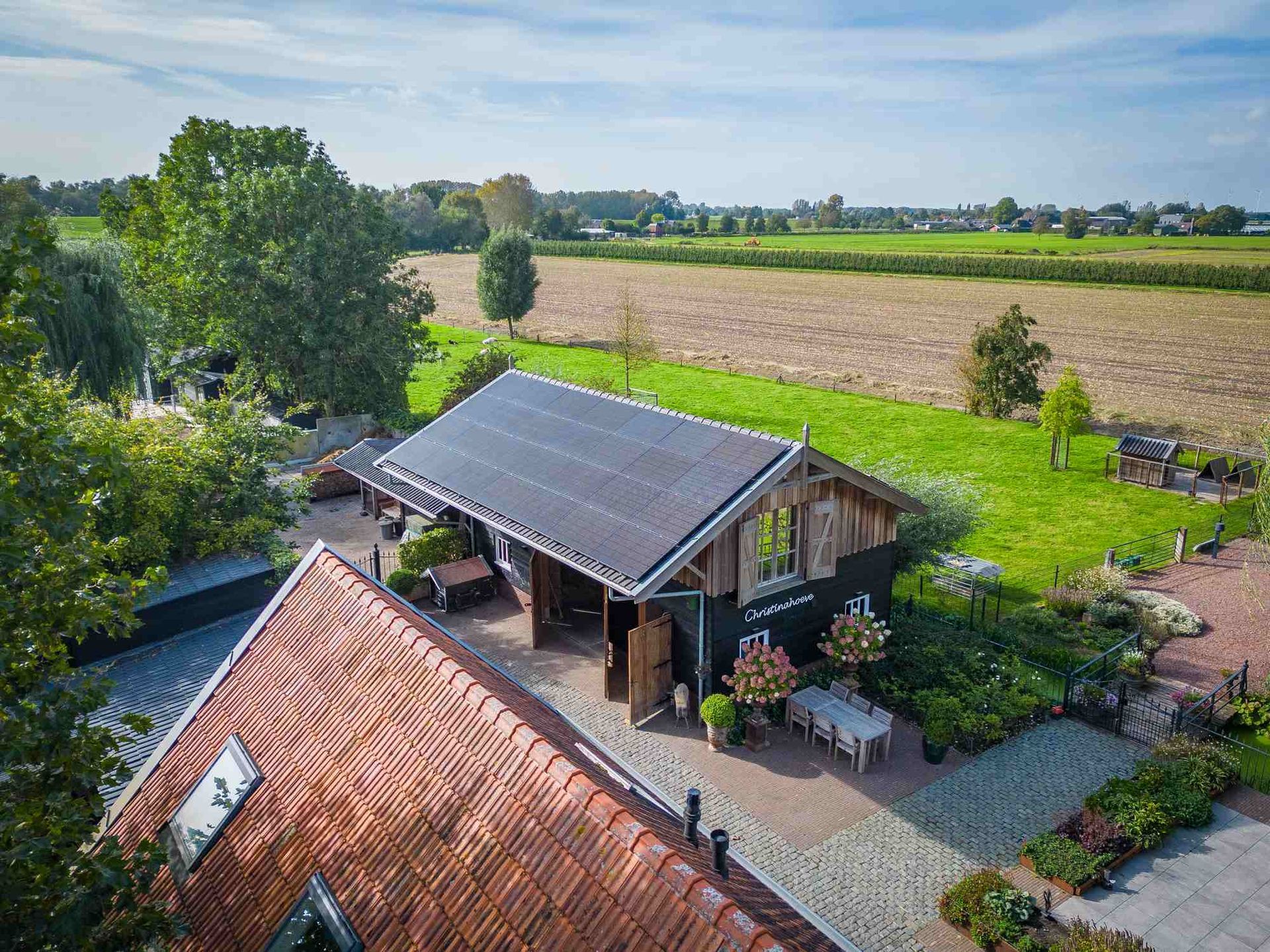 Een luchtfoto van een huis met zonnepanelen op het dak.