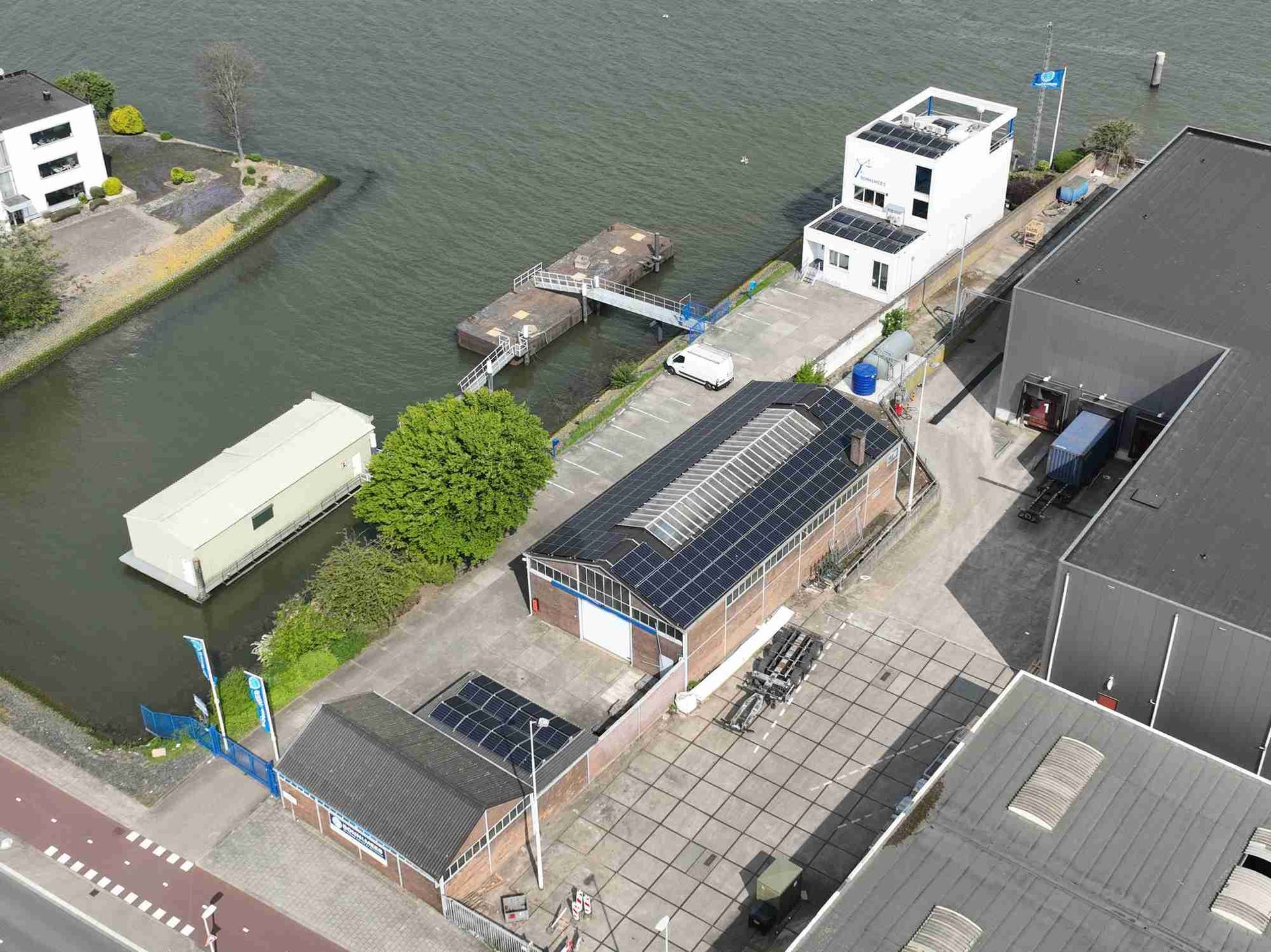 Een luchtfoto van een gebouw naast een waterpartij.