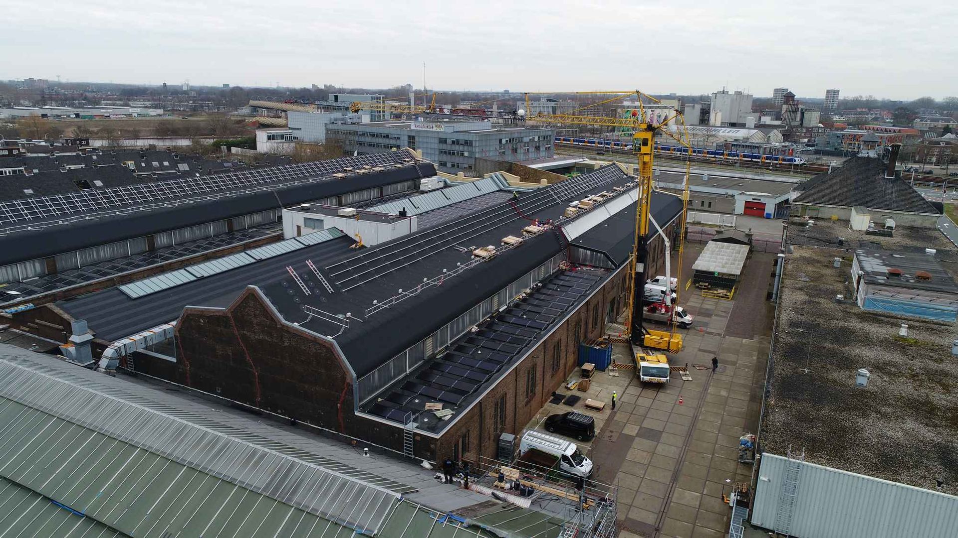 Een luchtfoto van een groot gebouw in aanbouw in een stad.