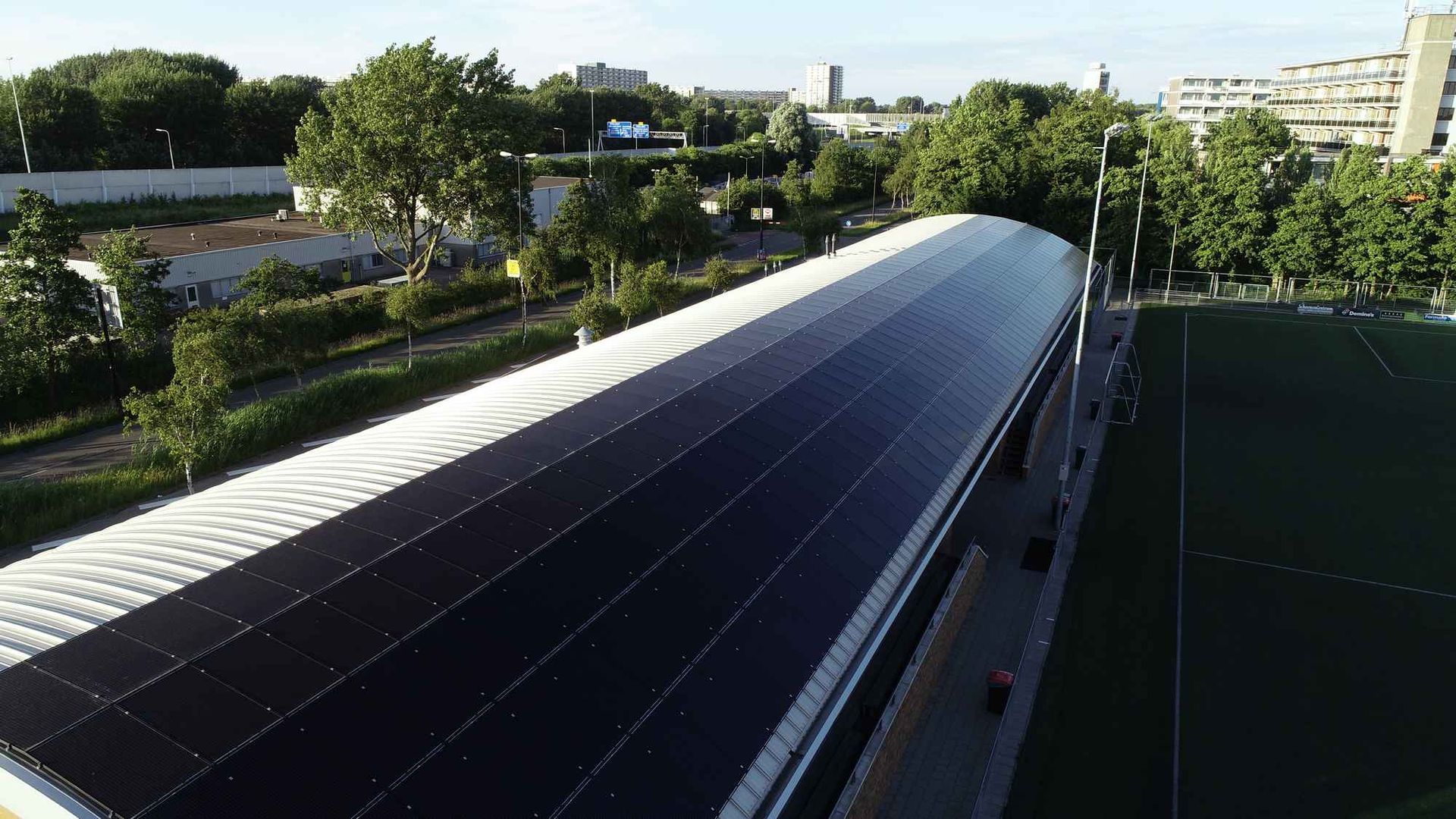 Een luchtfoto van een gebouw met zonnepanelen op het dak.