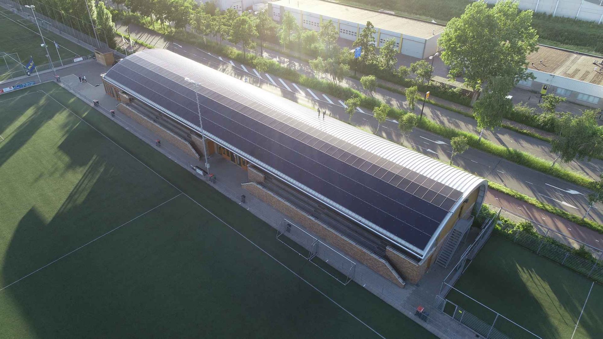Een luchtfoto van een gebouw met zonnepanelen op het dak.