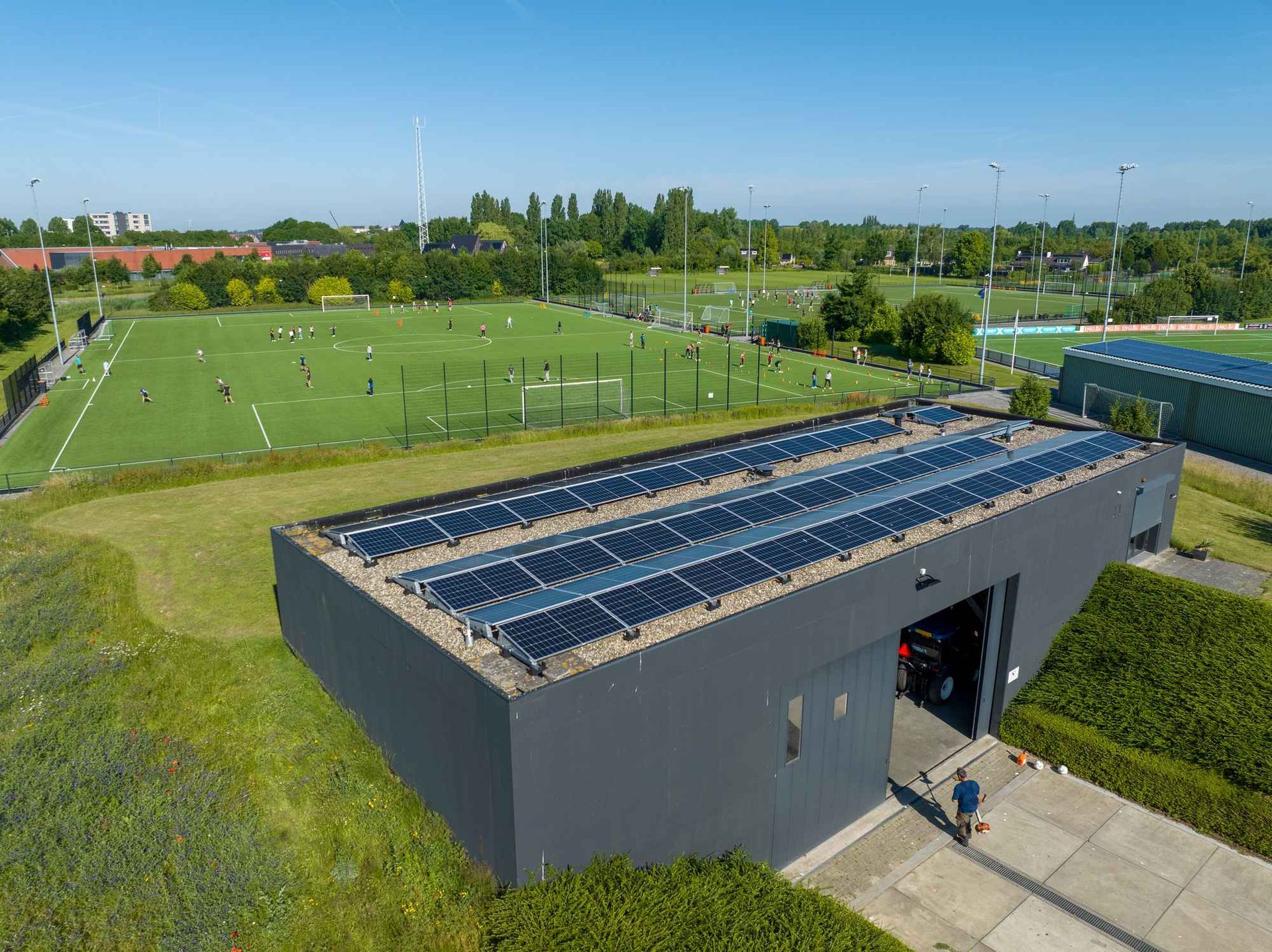 Een luchtfoto van een gebouw met zonnepanelen op het dak.