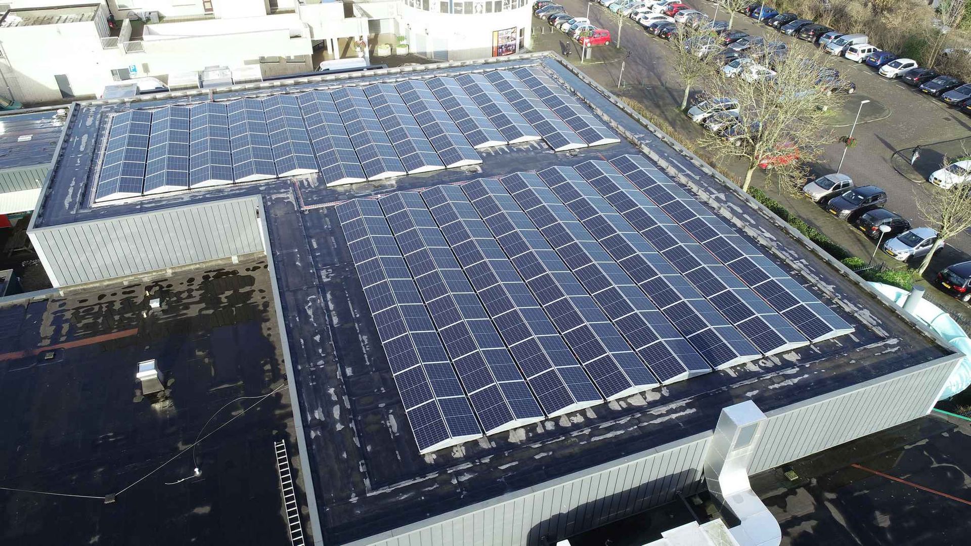 Een luchtfoto van een gebouw met zonnepanelen op het dak.