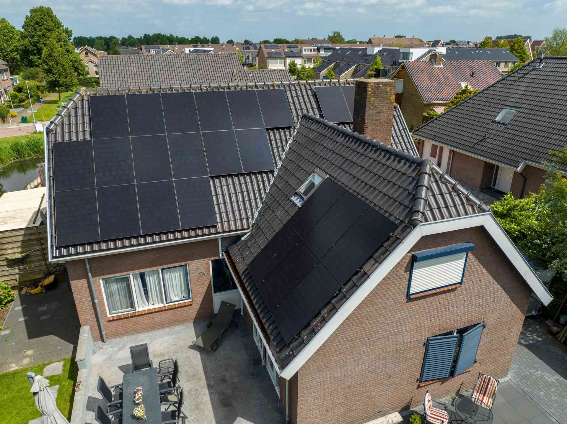 Een luchtfoto van een huis met zonnepanelen op het dak.