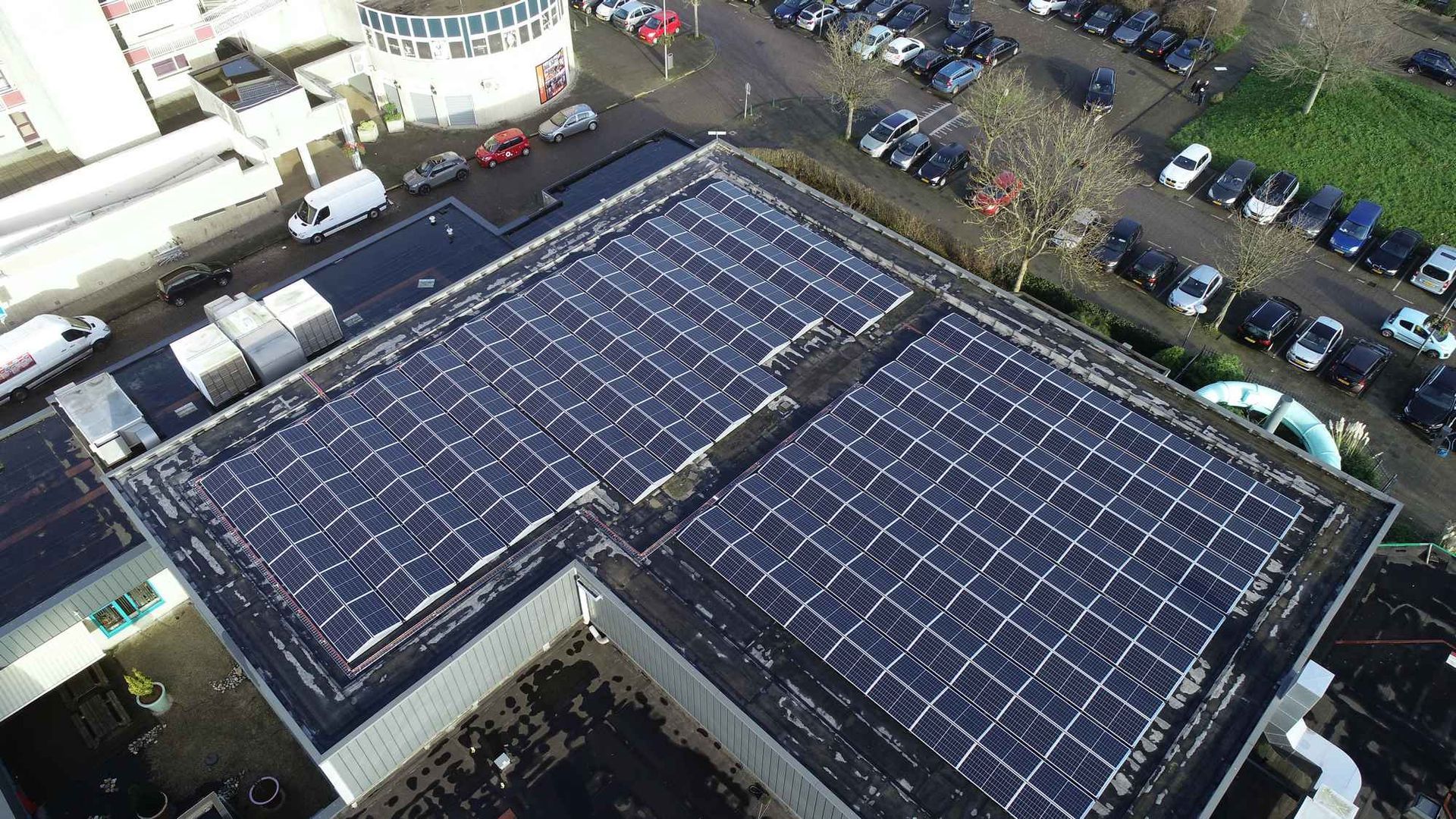Een luchtfoto van een gebouw met zonnepanelen op het dak.