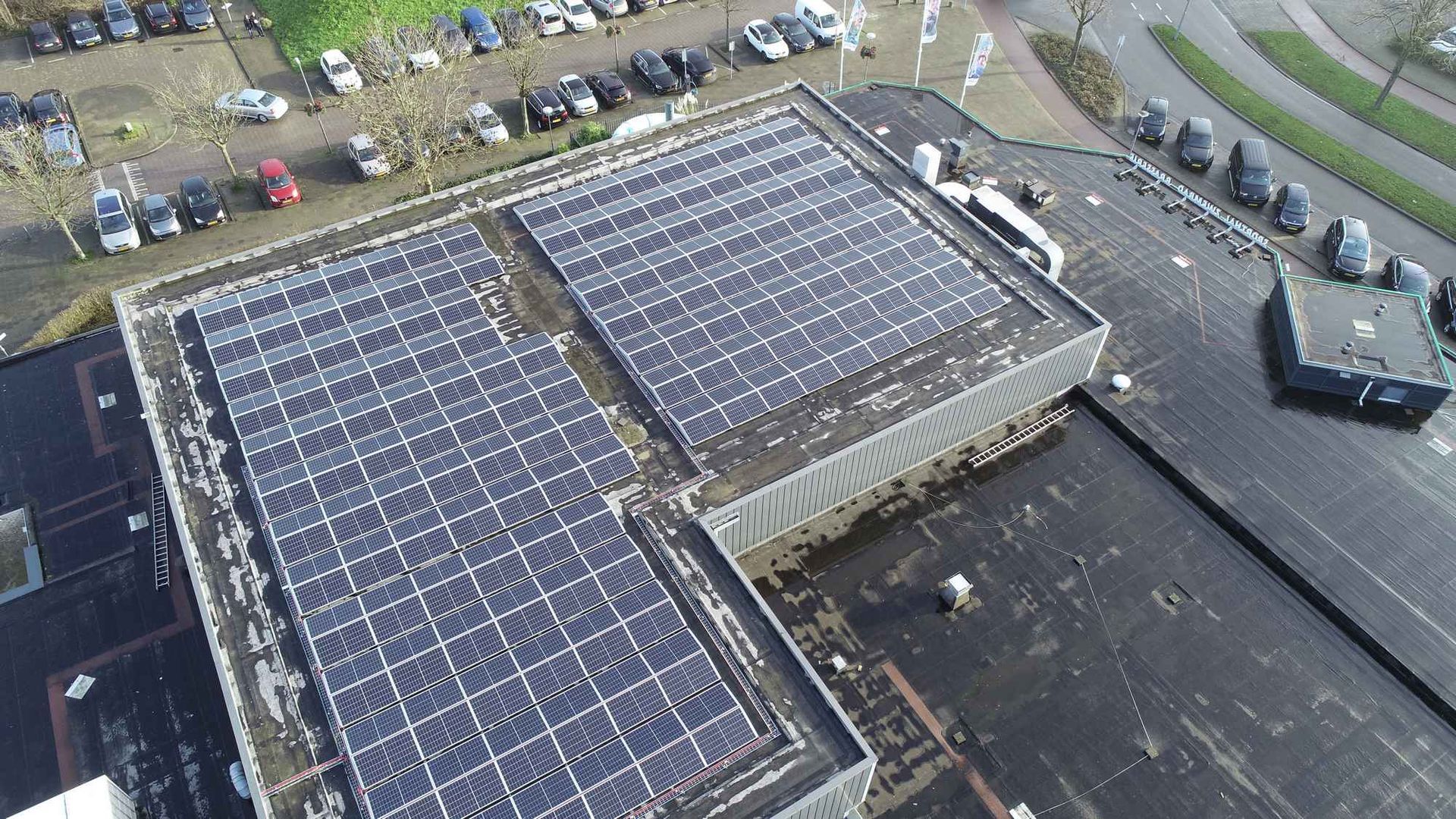 Een luchtfoto van een gebouw met zonnepanelen op het dak.