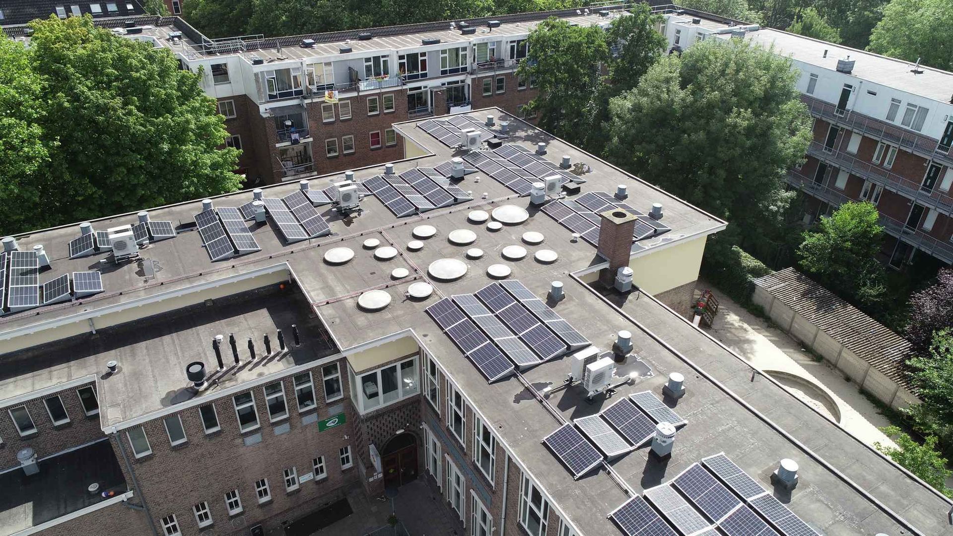 Een luchtfoto van een gebouw met zonnepanelen op het dak