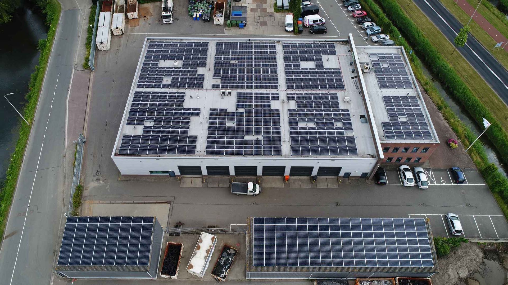 Een luchtfoto van een gebouw met zonnepanelen op het dak.