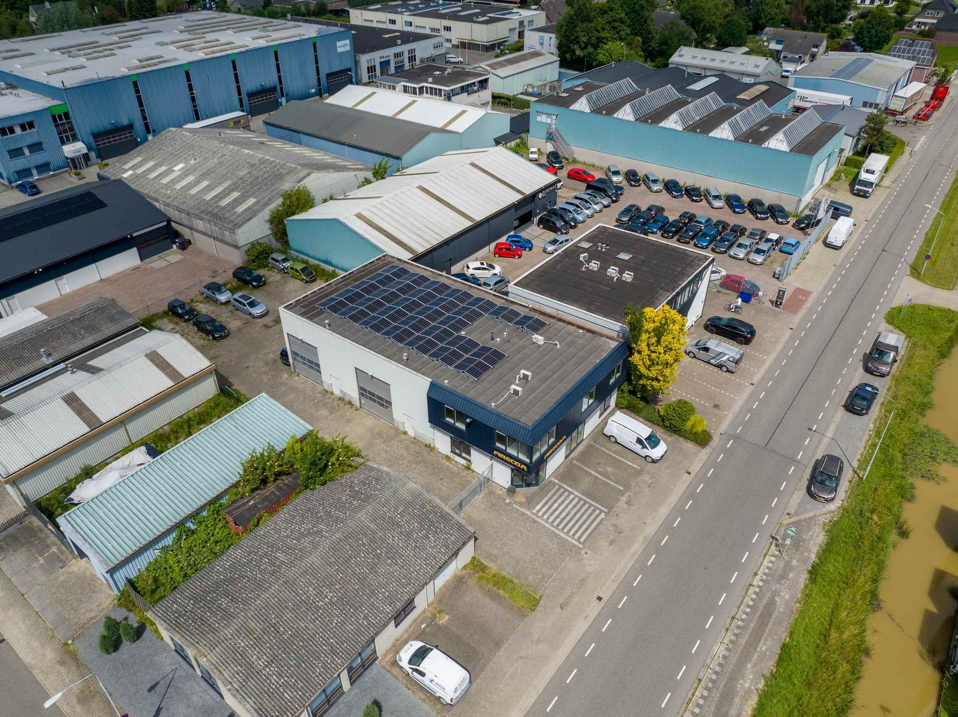 Een luchtfoto van een magazijn met zonnepanelen op het dak.