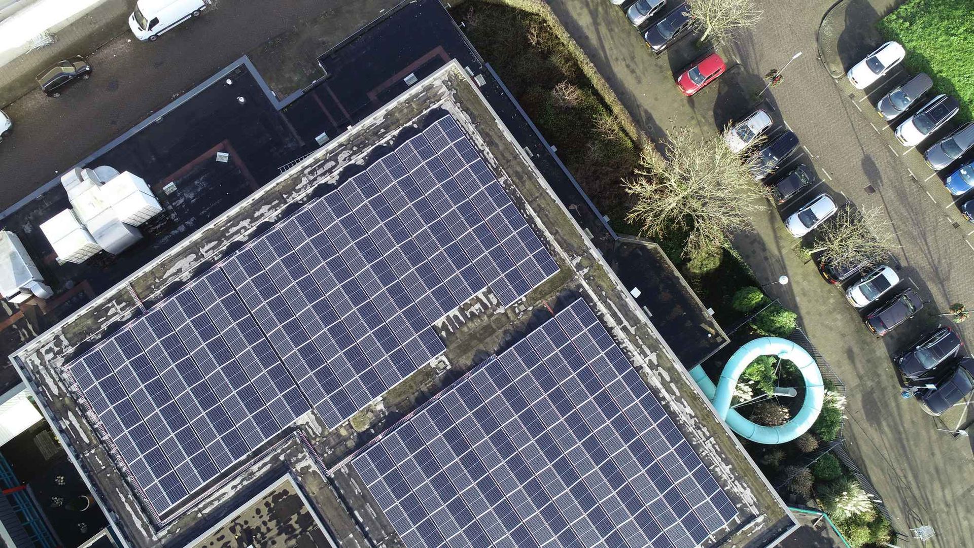 Een luchtfoto van een gebouw met zonnepanelen op het dak.