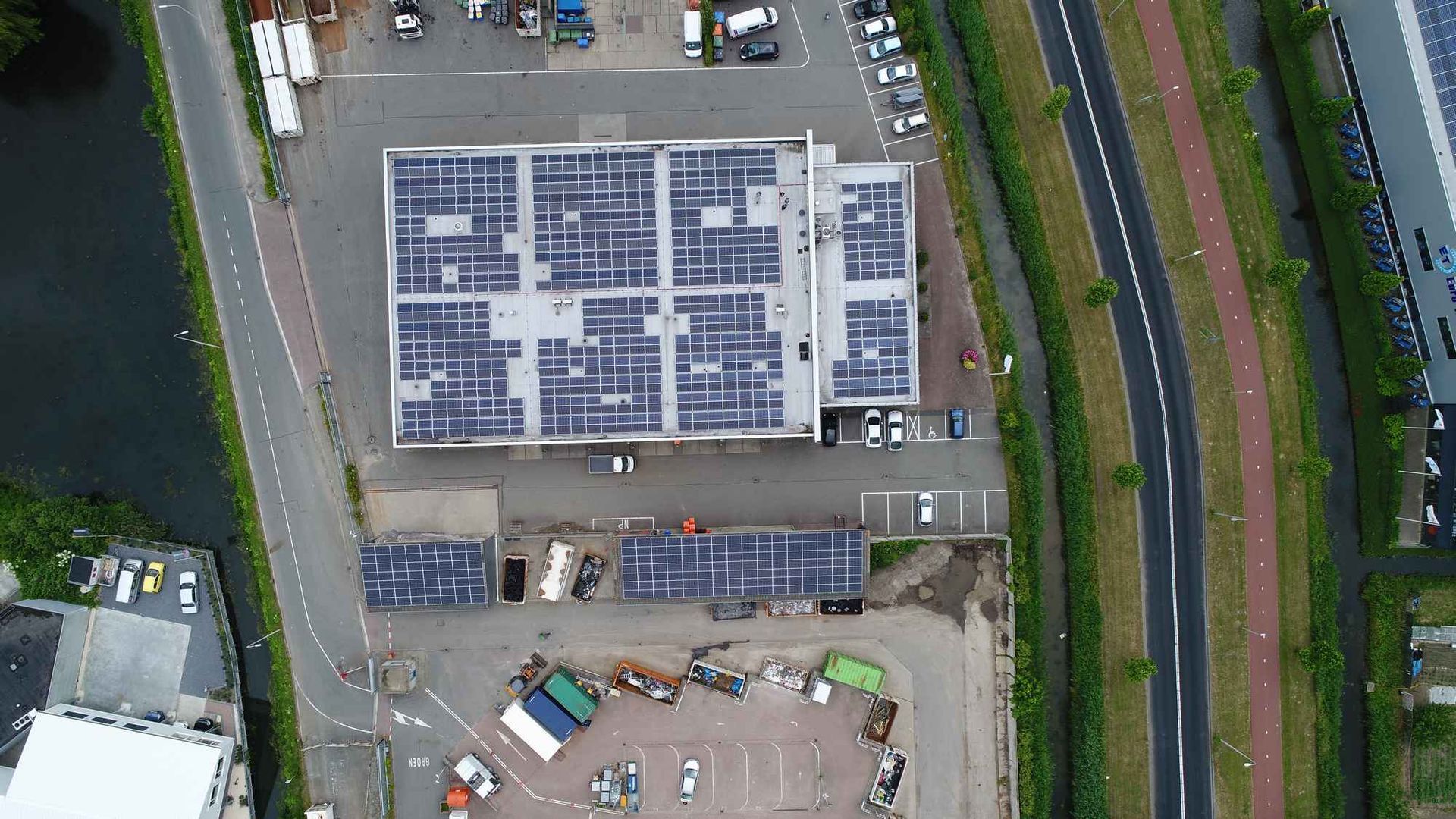 Een luchtfoto van een gebouw met zonnepanelen op het dak.