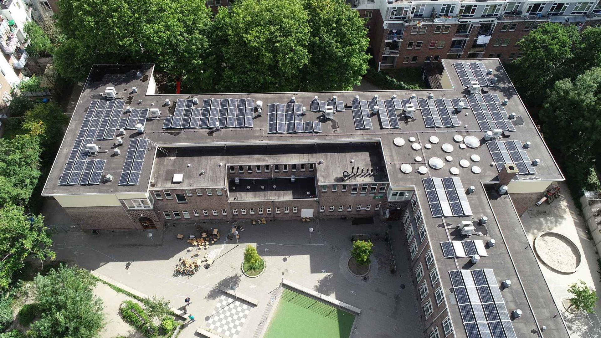 Een luchtfoto van een gebouw met zonnepanelen op het dak