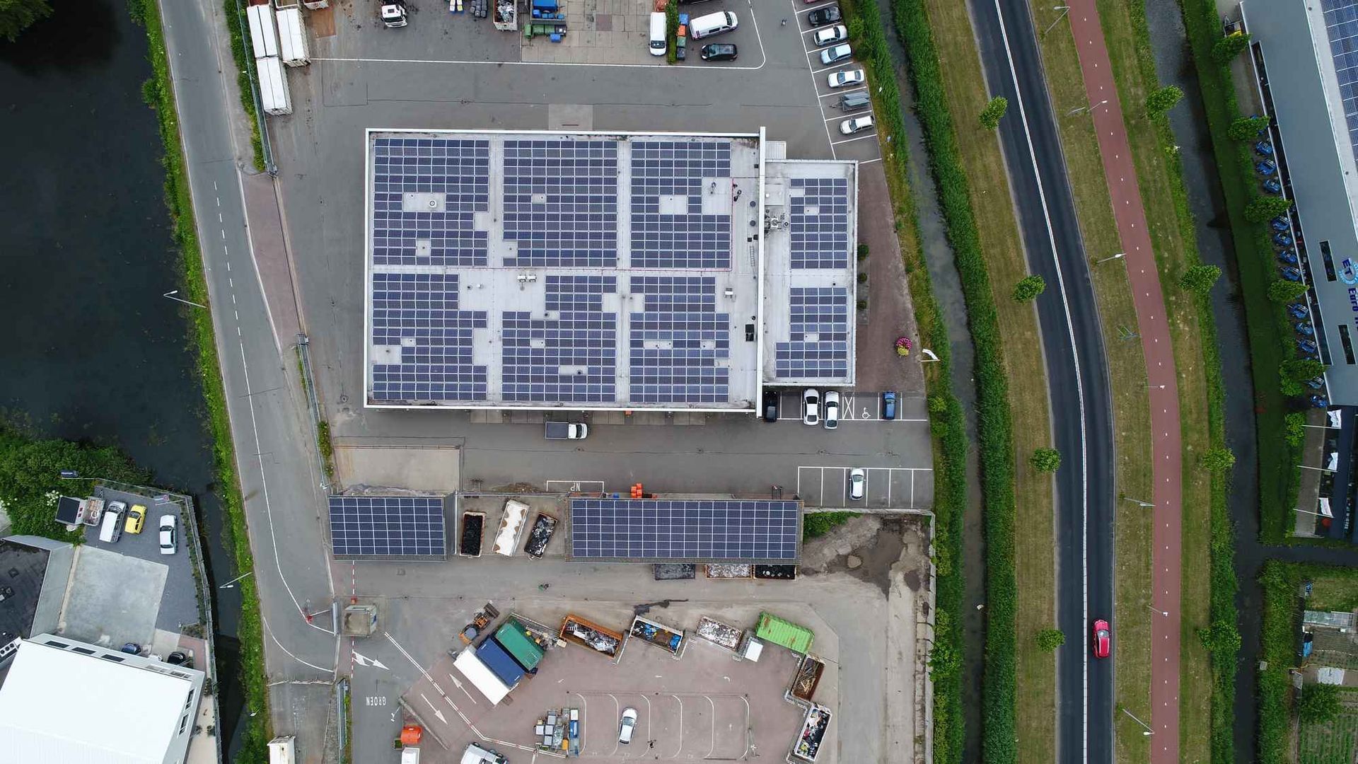 Een luchtfoto van een gebouw met zonnepanelen op het dak.