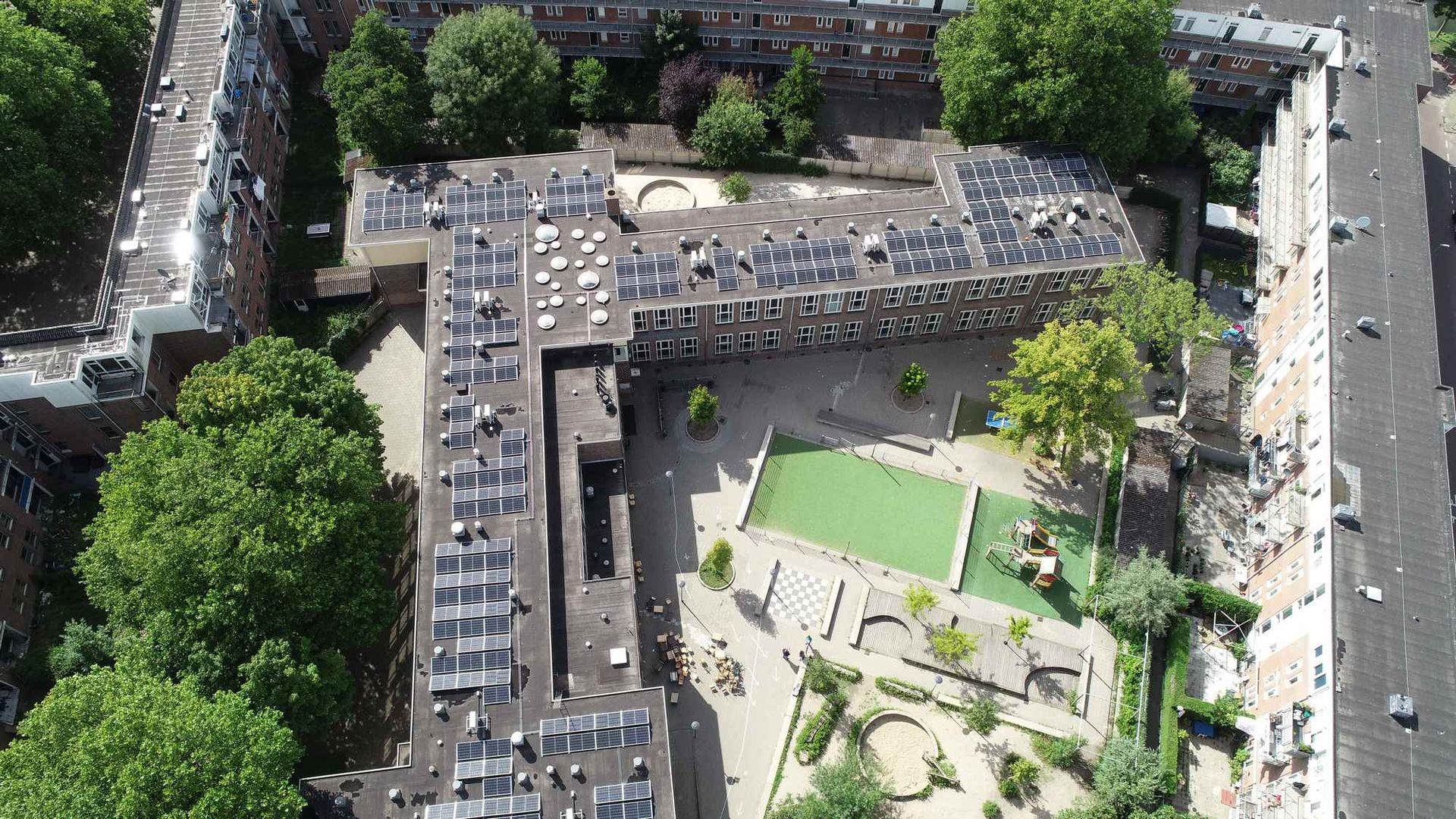 Een luchtfoto van een stad met veel gebouwen en bomen