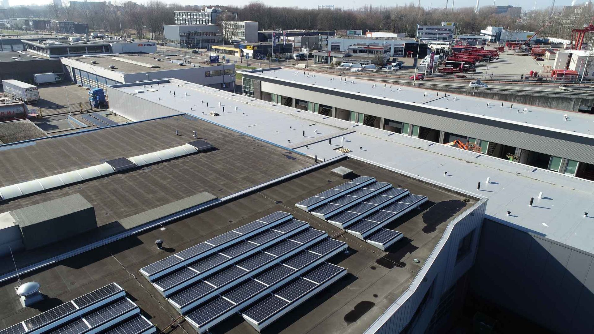 Een luchtfoto van een gebouw met zonnepanelen op het dak