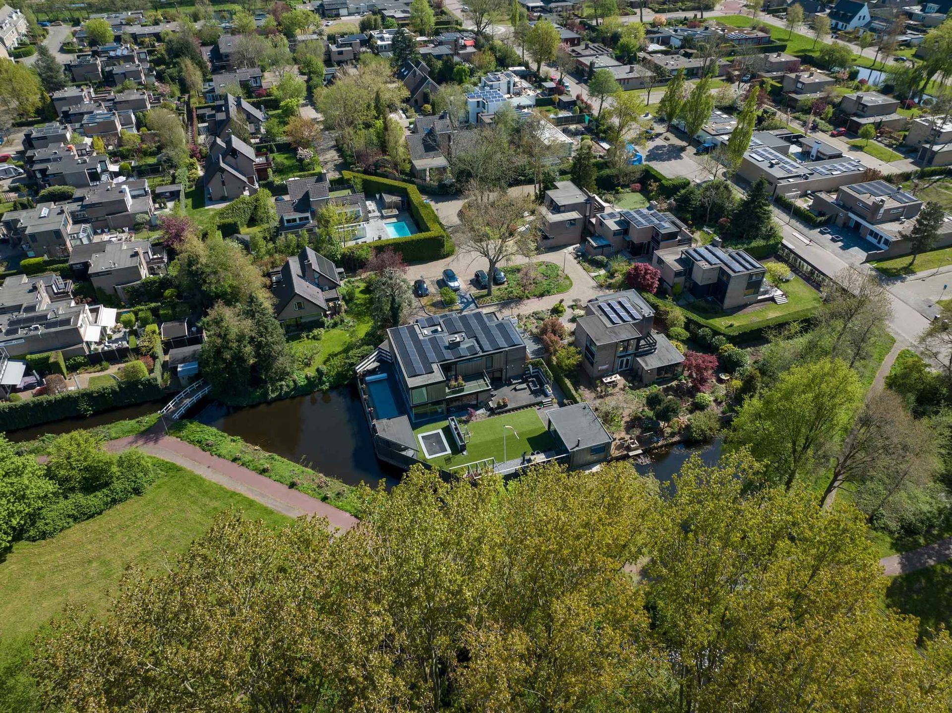 Een luchtfoto van een woonwijk met veel huizen en bomen.