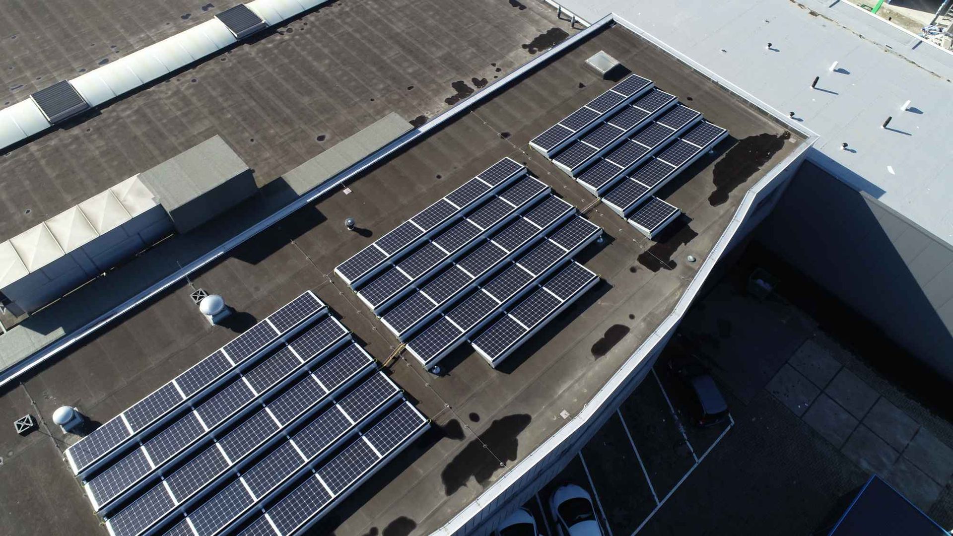 Een luchtfoto van een gebouw met zonnepanelen op het dak.