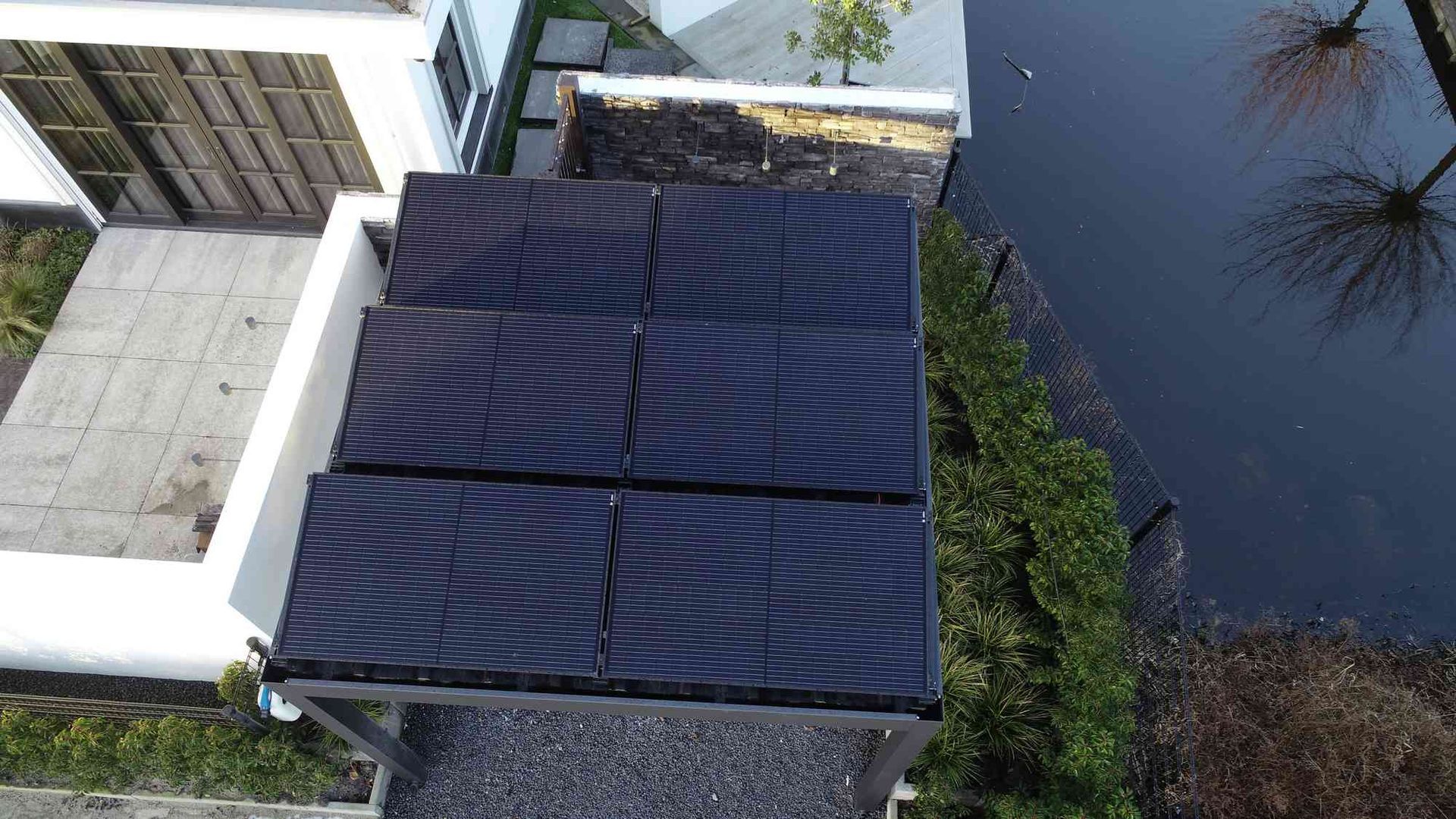Een luchtfoto van een huis met zonnepanelen op het dak.