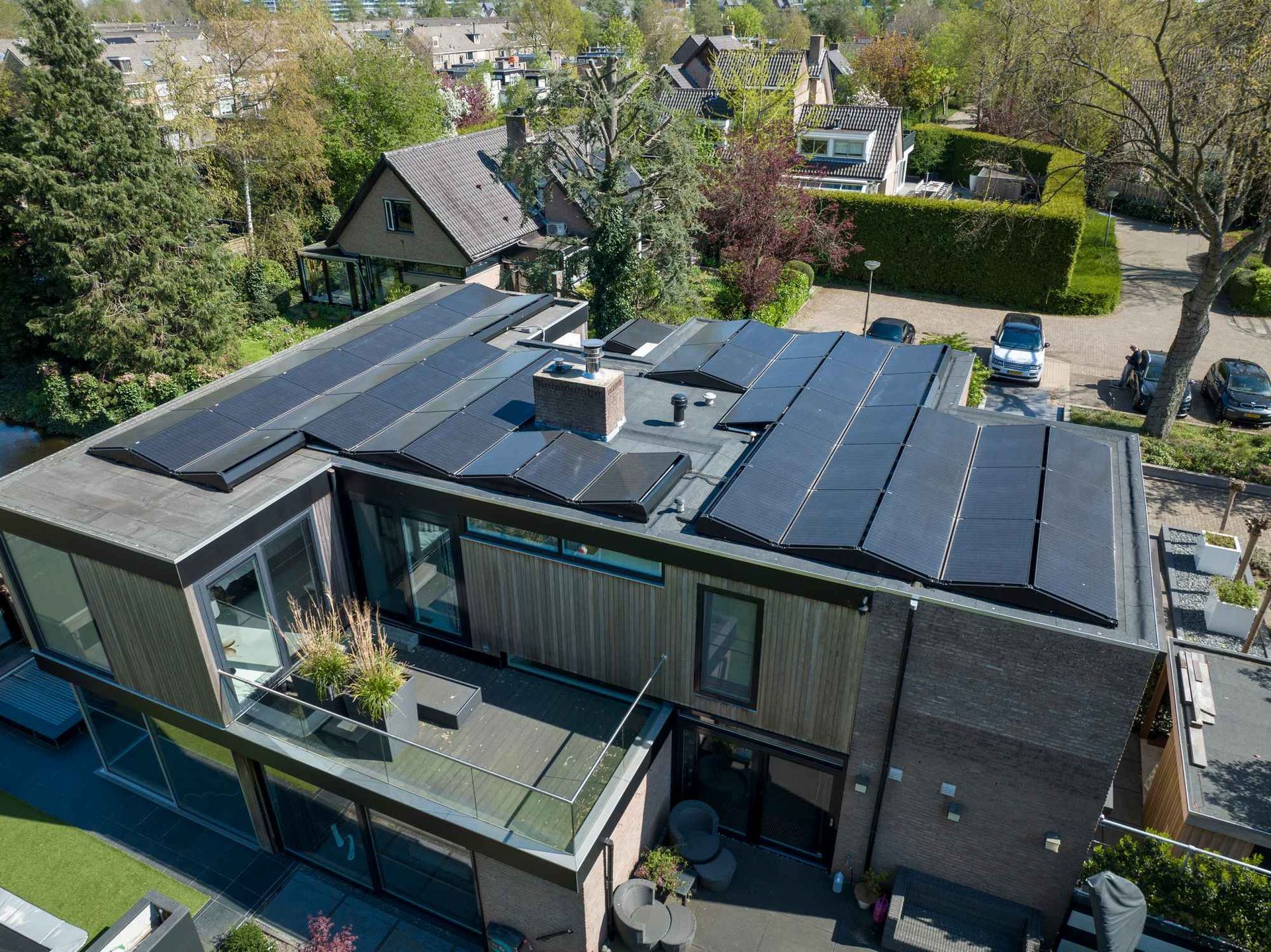 Een luchtfoto van een huis met zonnepanelen op het dak.