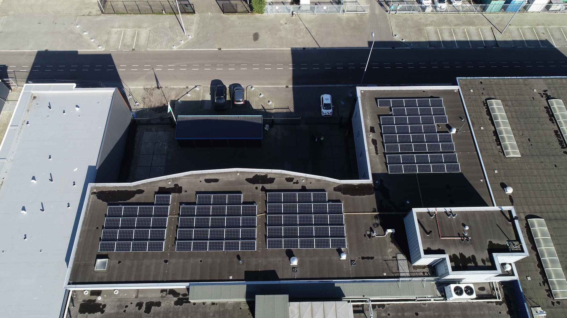 Een luchtfoto van een gebouw met zonnepanelen op het dak