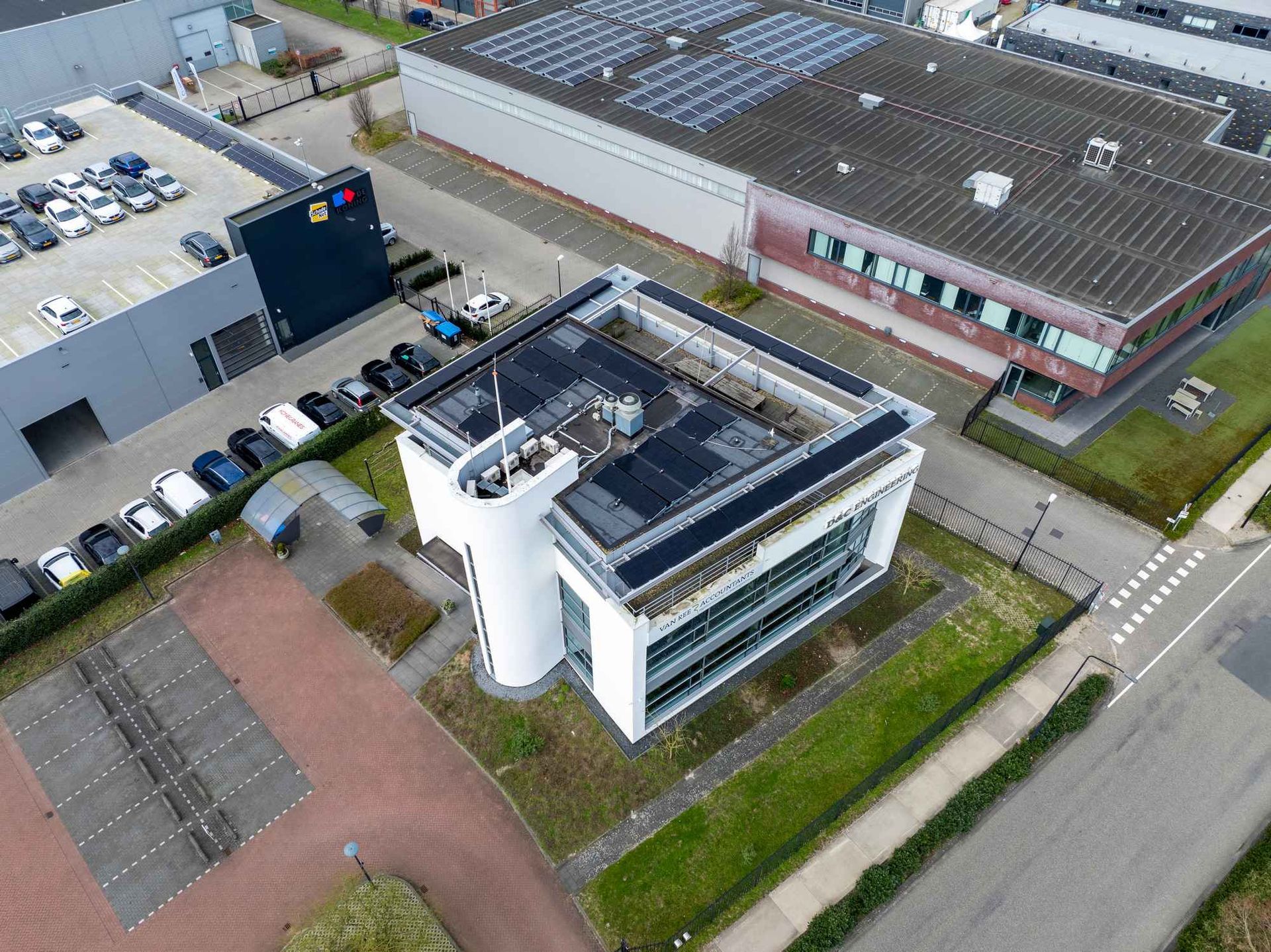 Een luchtfoto van een gebouw met zonnepanelen op het dak.
