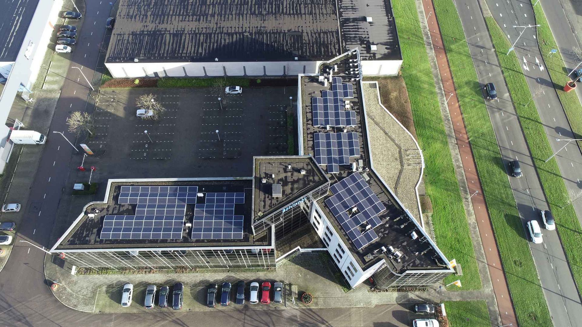 Een luchtfoto van een gebouw met zonnepanelen op het dak