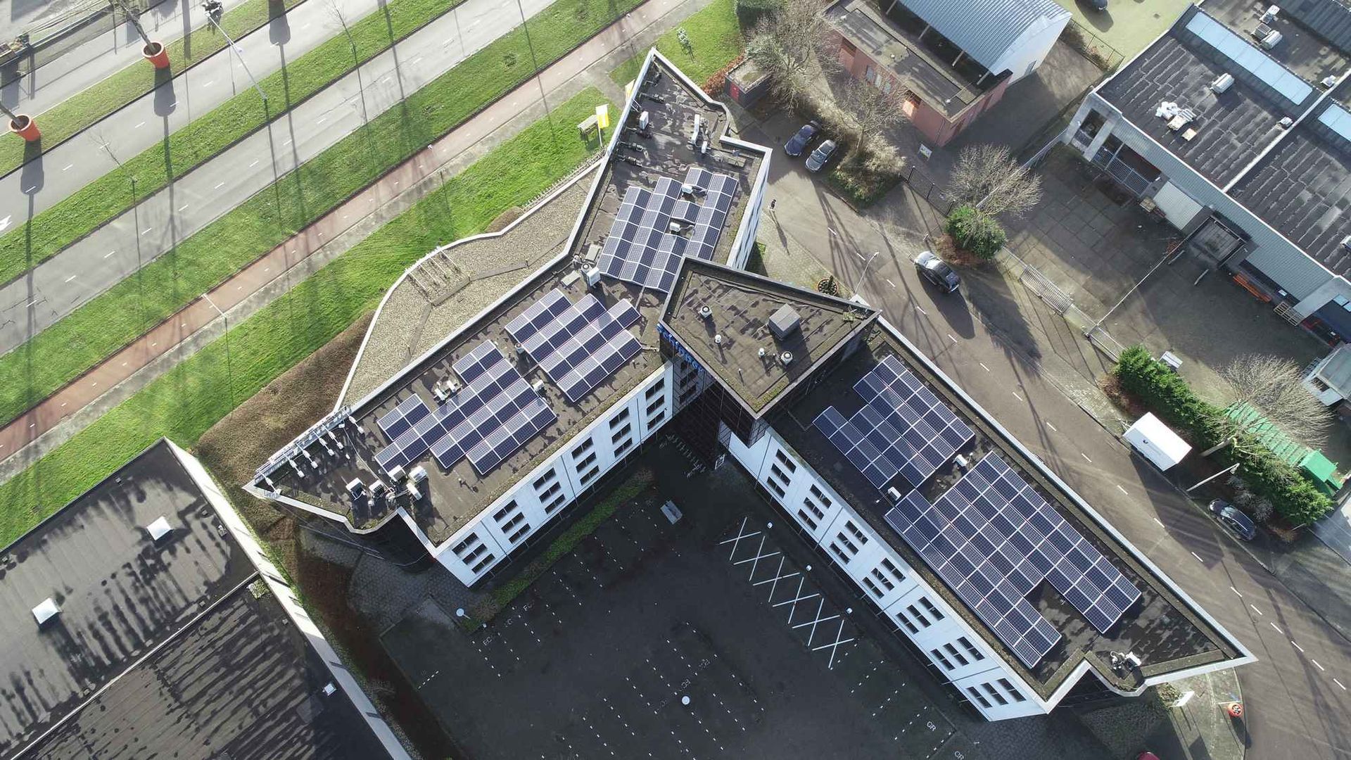 Een luchtfoto van een gebouw met zonnepanelen op het dak