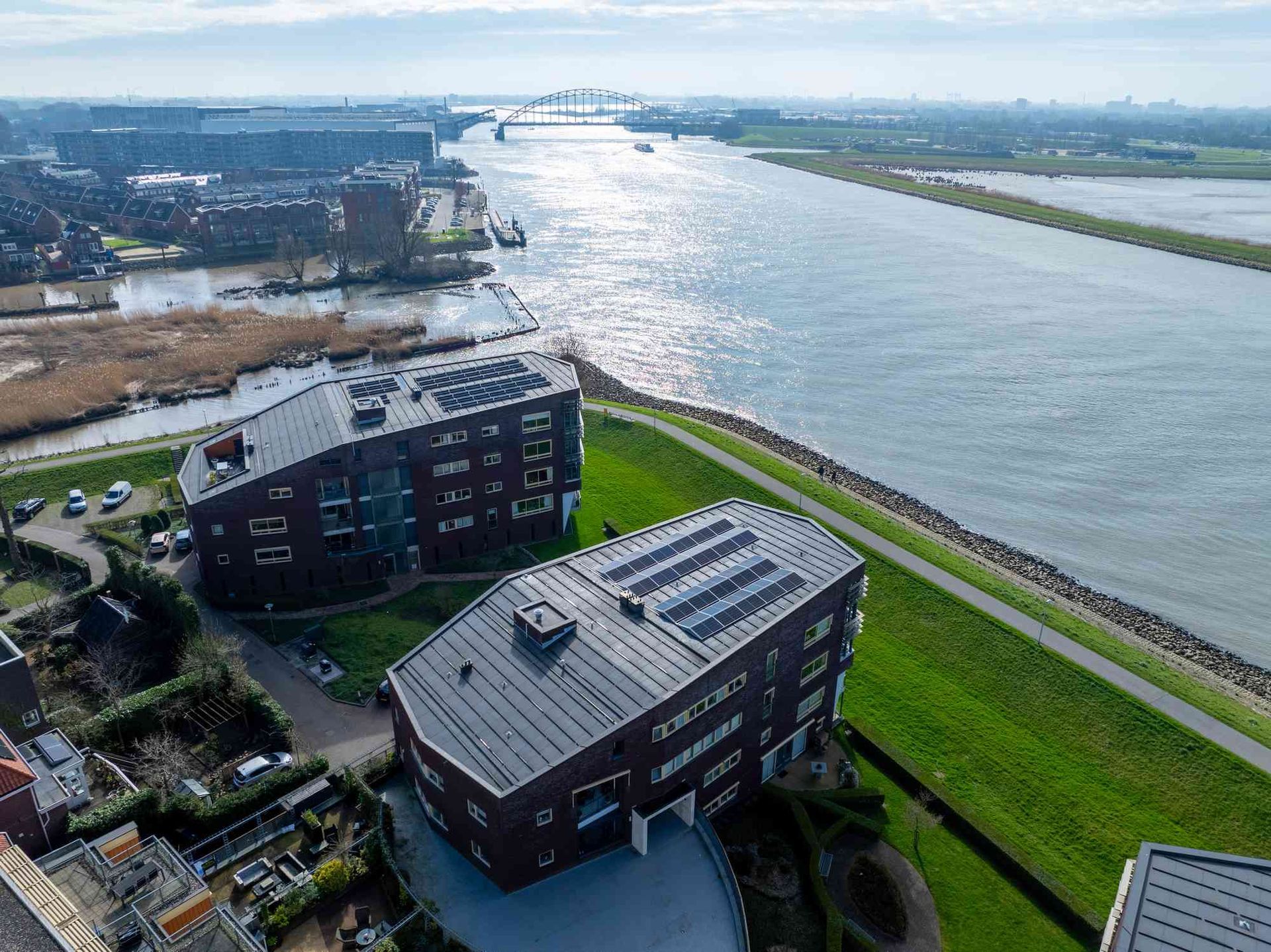 Een luchtfoto van een groot gebouw naast een rivier.